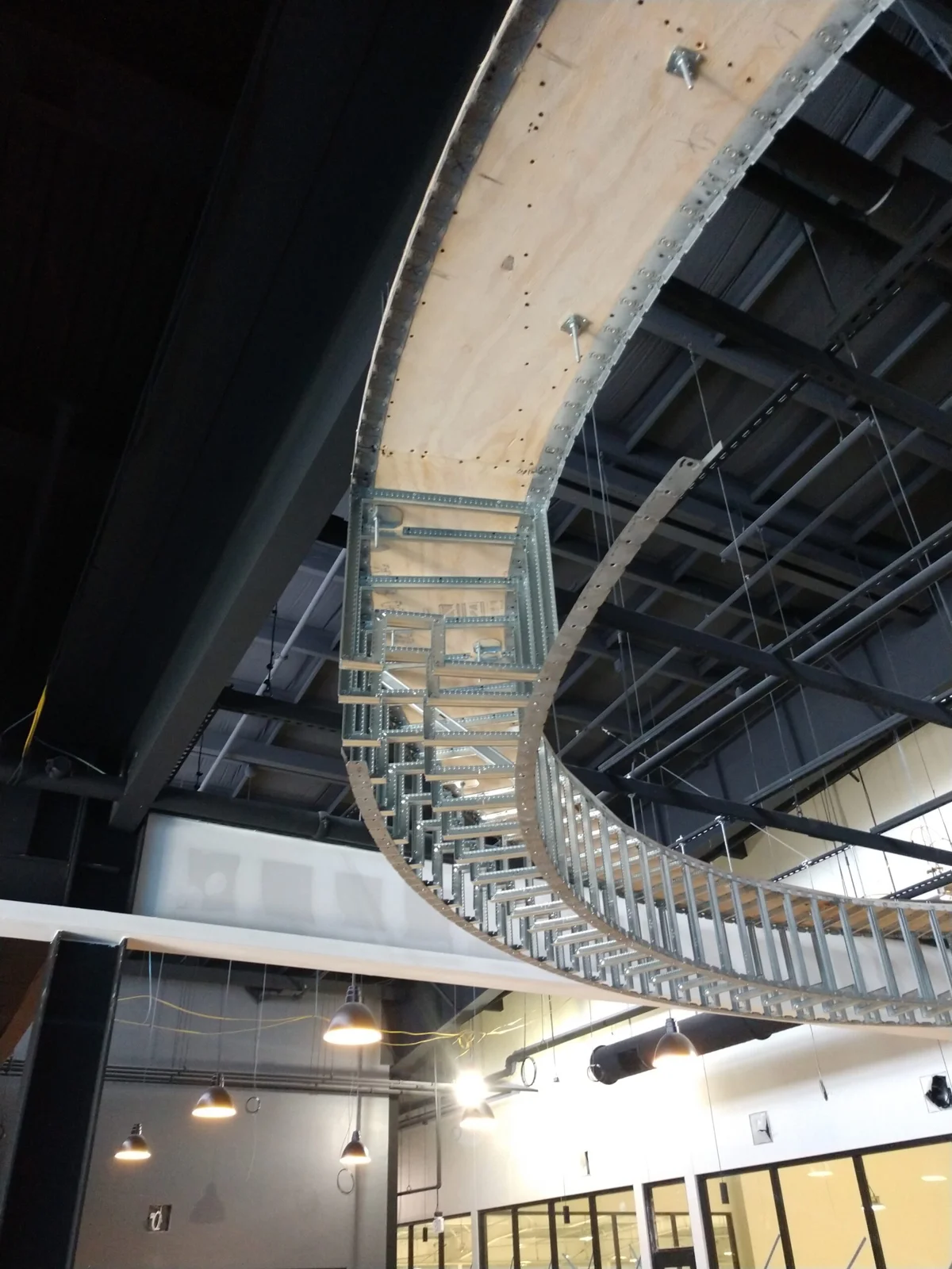 Curved metal framing and rough carpentry forming an interior soffit
